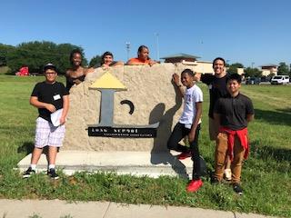 Students surround the Long School sign